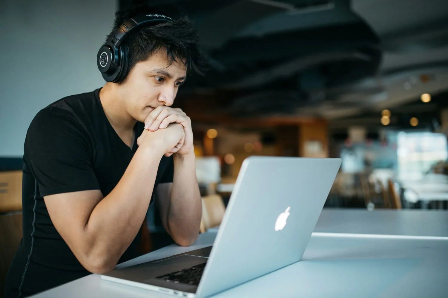 A man watching a webinar on a laptop with headphones